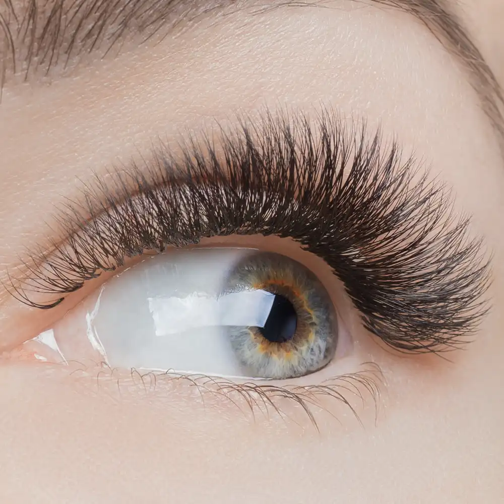 Close-up of a hazel-blue eye with volume 2D-6D eyelash extensions, creating a full and dramatic look.